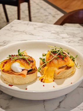 Beyaz tabakta Benedict yumurtaları. Nefis kahvaltı seti..