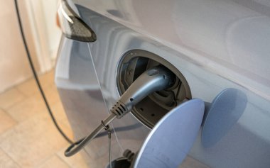 Evde elektrikli araba şarj oluyor, bir duvar kutusundan. Yüksek açı görünümü.