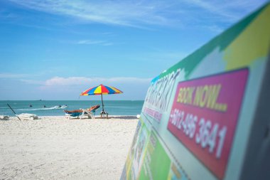 Langkawi, Malezya - 3 Ocak 2025: Langkawi 'nin en popüler plajlarından biri olan Pantai Cenang' da güneşlenen turist.