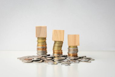 Bozuklukların üstünde üç oyuncak blok var ve masanın üzerinde yatıyor. Beyaz arkaplanda izole.