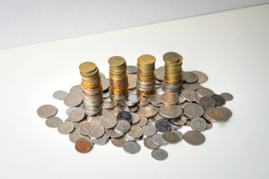 Bozuk paralar, istiflenmiş ve beyaz yüzeyde duruyor. Boşluğu kopyala.