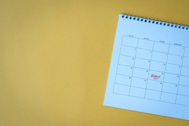 Sarı yüzey üzerinde olay hatırlatıcısı olan takvim sayfası. Düz yat, boşluğu kopyala.