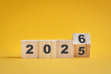 2025 'ten 2026' ya dönün, kare bloklar sarı yüzeyde izole edilmiş..