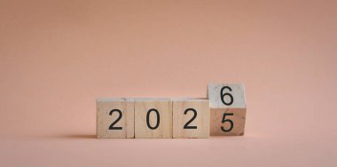 Kare bloklar, 2025 'ten 2026' ya dönüyor. Yeni yıl konsepti. Açık bej arkaplanda izole edilmiş, art arda bloklar.