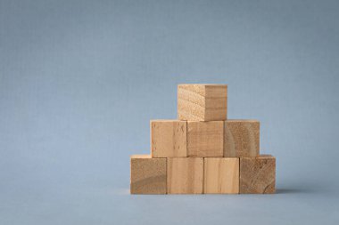 Tahta bloklar piramit şeklinde dizilmiş. Işık arkaplanında izole edilmiş, boşluğu kopyala.