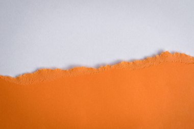 Turuncu kağıt, beyaz renkli kağıdın üzerinde yarı yarıya dinleniyor. Pankart reklamı için, alanı kopyala.