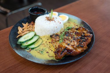 Hindistancevizi buğulamalı pilav, bol baharatlı tavuk ve köri sosuyla servis edilir..