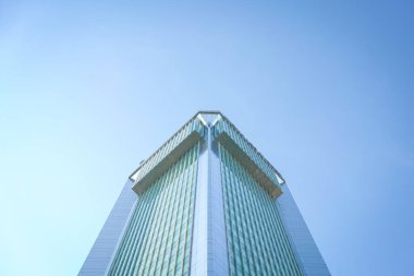 Mavi gökyüzüne karşı çok katlı bir bina. Düşük açı, boşluğu kopyala.