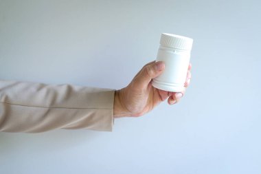 Elinde beyaz bir şişe tutan kişi. Beyaz arkaplanda izole edilmiş, görünümü kapat.