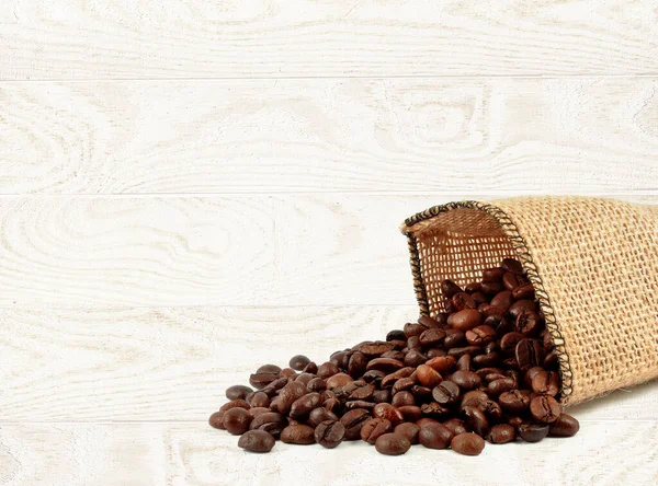 coffee beans in a bag on a light wooden background
