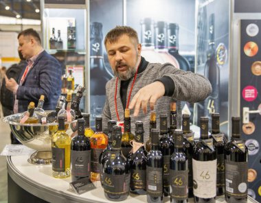 Kyiv, Ukrayna - 29 Mart 2023: Sunucu, MVC 'deki Uluslararası Şarap ve Ruhlar Sergisi sırasında 46 Paralel Şarap Şirketi standında çalışıyor.