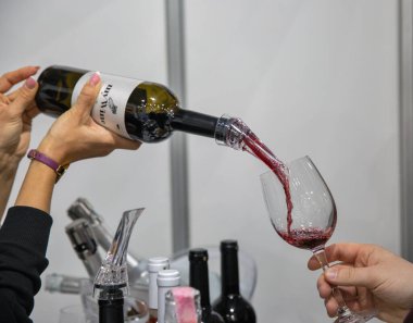 Kyiv, Ukrayna - 29 Mart 2023: MVC 'deki Uluslararası Şarap ve Ruhlar Sergisi' nde tatmak için Eduard Gorodetsky 'nin hazırladığı kırmızı şarabımı döküyorum.