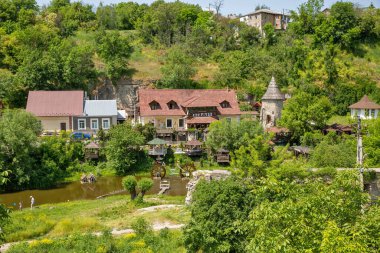 Kamianets-Podilsky, Ukrayna - 29 Mayıs 2023: İnsanlar nehrin yakınındaki turistik halk kompleksini ziyaret ediyor. Kamianets-Podilskyi, Ukrayna 'nın batısında, Chernivtsi' nin kuzeydoğusunda yer alan bir şehirdir..