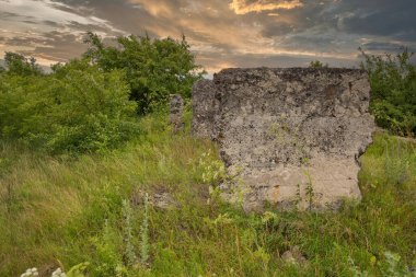 Dramatik günbatımı gökyüzüne karşı eski bir binanın kalıntıları.