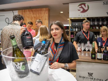 Kyiv, Ukrayna - 30 Eylül 2023: Kadın sunucu Be Wine International Wine Show sırasında şarap tatmada çalışıyor.