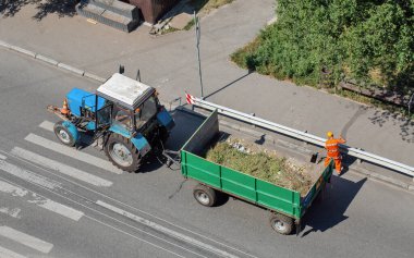 Eski traktörün sokak çöplerini temizlemek için bir karavanı var.