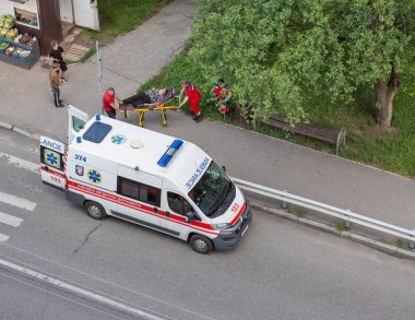 Kyiv, Ukrayna - 21 Temmuz 2023: Bir belediye ambulans ekibi, şehir parkındaki üst düzey bir hastaya yardım sağlıyor.