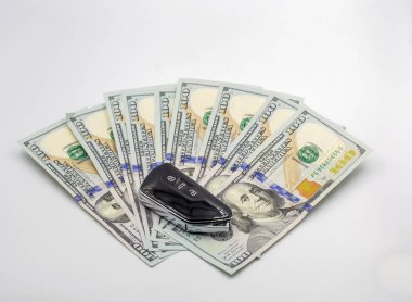Modern yeni araba yakınlığı anahtarı 100 doların üzerinde banknotlar beyaz üzerine yakın çekim