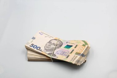 Bir paket Ukrayna Hryvna banknotları düzgün düzenlenmiş ve kullanılmaya hazır lastik bantlar tarafından bir arada tutuluyor. Beyaza yaklaştır.