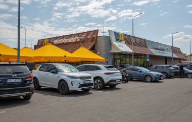 Lisniki, Kyiv, Ukrayna - 18 Mayıs 2024: Arabalar McDonald 's fast food restoranının önüne park edildi. 1940 yılında kurulan çok uluslu bir fast food zinciri..