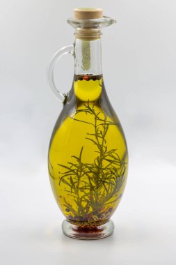 Şeffaf zeytinyağı şişesi, beyaz bitkiler ve tohumlar..