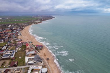 Romanya 'nın Karadeniz kıyısındaki Vama Veche veya Eski Gümrük tatil köyü üzerindeki hava aracı manzarası. Uzaktaki Mangalia limanı.