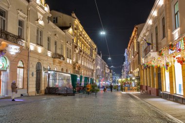 Chernivtsi, Ukraine - December 23, 2024: Kobylyanska Street decorated for Christmas at night. Chernivtsi is the capital of historic region of Bukovina, which is now divided between Romania and Ukraine clipart