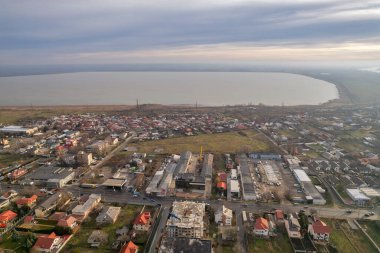 Sabahın köründe şehir manzarasında uzaktan görülebilen Brates Gölü 'yle insansız hava görüntüsü. Galati, Romanya.