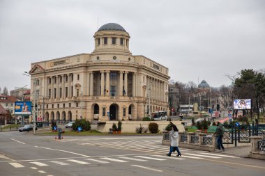 Iasi, Romania - December 26, 2024: People walk along Mihai Eminescu Square with University Library building in downtown. clipart