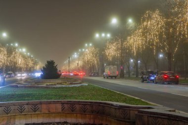 Bükreş, Romanya - 31 Aralık 2024: Gece olmadan önce sisli havada Union veya Unirii Bulvarı. Büyük bir cadde Anayasa Meydanı 'nı Alba Iulia Meydanı' na bağlıyor.