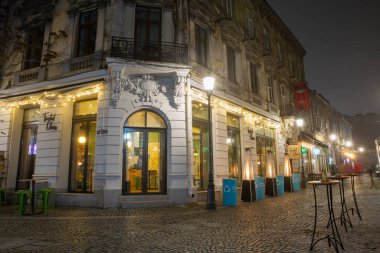 Bükreş, Romanya - 31 Aralık 2024: Eski Kentin gece caddesi şehir merkezinde yer alıyor ve gece hayatı ile tanınıyor. Eski binalar, insanlar, barlar, kafeler ve restoranlarla sokak manzarası.