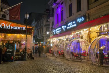 Bükreş, Romanya - 31 Aralık 2024: Eski Kentin gece caddesi şehir merkezinde yer alıyor ve gece hayatı ile tanınıyor. Eski binalar, insanlar, barlar, kafeler ve restoranlarla sokak manzarası.