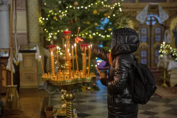 Kadın kilisede mum yakıyor. Ortodoks Kilisesi 'nde şamdan. Yakın plan. Kilisenin iç güzelliği ve huzuru..