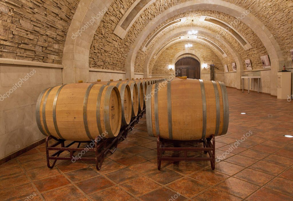 Purcari, Moldova - January 03, 2025: Wine oak barrels closeup in the cellar of wine producer. Purcari Winery has entered over 30 markets in Europe, North America and East Asia.