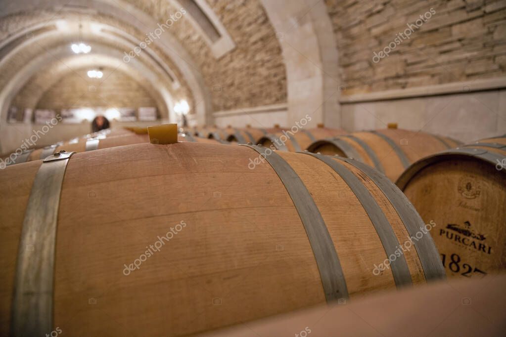 Purcari, Moldova - January 03, 2025: Wine oak barrels closeup in the cellar of wine producer. Purcari Winery has entered over 30 markets in Europe, North America and East Asia.