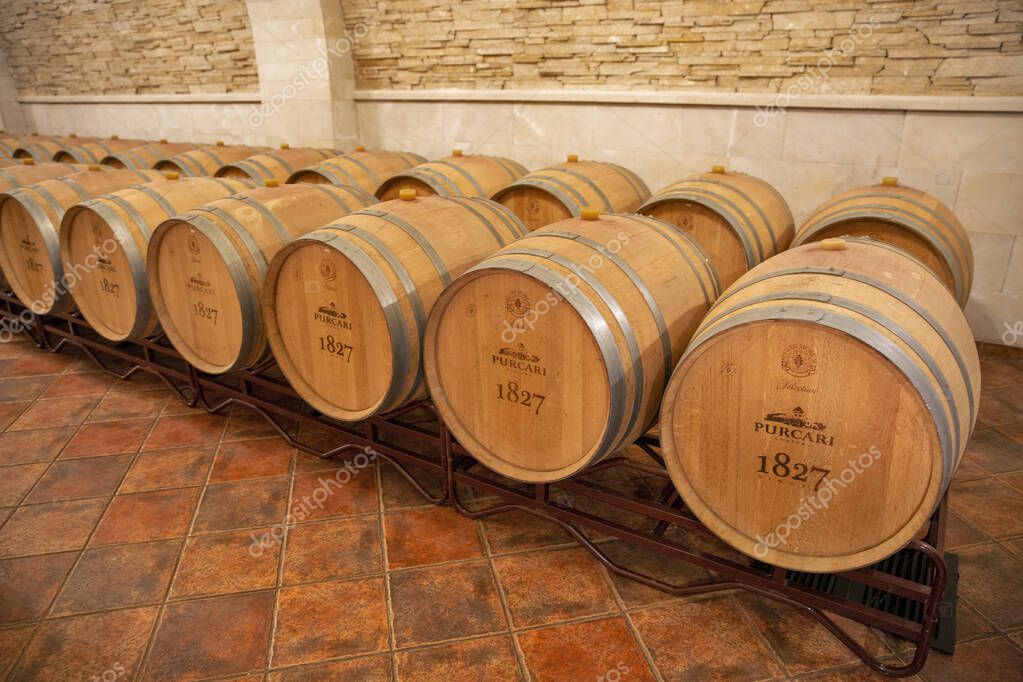 Purcari, Moldova - January 03, 2025: Wine oak barrels closeup in the cellar of wine producer. Purcari Winery has entered over 30 markets in Europe, North America and East Asia.