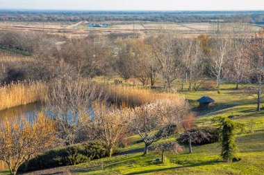 Moldova 'nın Purcari kentindeki bahçe gölü, üzüm bağları ve tarım arazileri ile resmedilmiş kırsal sonbahar manzarası.