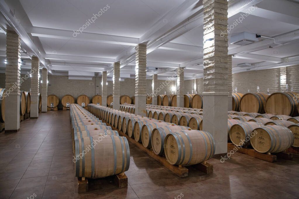 Purcari, Moldova - January 03, 2025: Wine oak barrels closeup in the cellar of wine producer. Purcari Winery has entered over 30 markets in Europe, North America and East Asia.