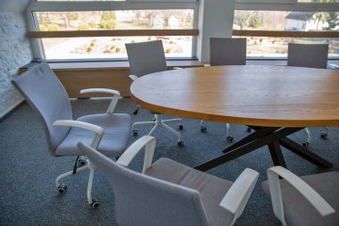 Ahşap masa ve ofis sandalyeleri olan modern boş toplantı odası.