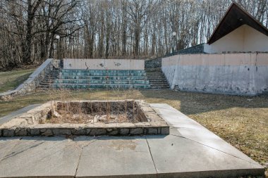 Ormanda unutulmuş bir anıt. Ormanlık alanda ihmal edilmiş bir kamu binası. Öncü kamp ateşi seremonisinin yeri..