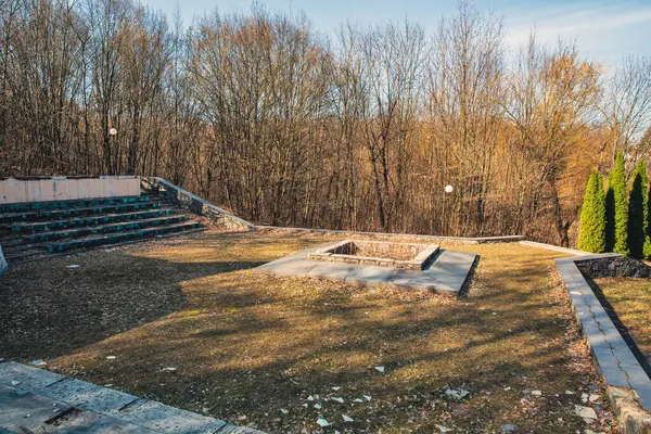 Ormanda unutulmuş bir anıt. Ormanlık alanda ihmal edilmiş bir kamu binası. Öncü kamp ateşi seremonisinin yeri..