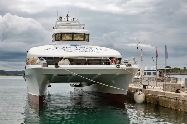 Porec, Hırvatistan - 21 Mayıs 2025: Kompas 'ın Adriyatik Hatları' ndan büyük beyaz bir katamaran bulutlu gökyüzünün altındaki limana demirledi. Parlak gemi Adriyatik Denizi 'nden yolcu transferi için hazır..