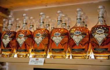 Novigrad, Hırvatistan - 22 Mayıs 2025: Altın kehribar armudu Aura Divlja Kruska brendi şişeleri ve yerel içki imalathanesinde geleneksel etiketler. Fiyat etiketli Istria bölgesinden Hırvat ruhları.