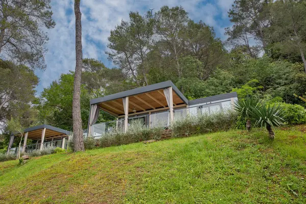 Hırvatistan 'ın tatil beldesinde yer alan çam ağaçları ve Akdeniz bitkileri arasında yeşil teraslı yamaçlara kurulmuş modern mobil evler.