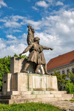 48. Piyade Alayı Anıtı. Askeri üniformalı iki askerin bronz heykeli, biri öne bakıyor diğeri de elinde bayrak, Macaristan 'ın Nagykanizsa kentindeki taş bir heykel üzerinde duruyor..