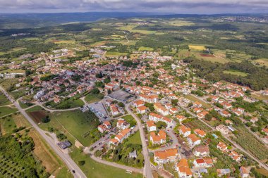 Hırvatistan 'ın Istria kentindeki Tar kentinin hava aracı görüntüsü, parçalı bulutlu bir yaz gökyüzü altında yerleşim bölgeleri, yeşil alanlar ve çevre kırsal alanları gösteriyor.