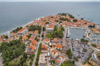Hırvatistan 'ın Istria kentindeki ortaçağ kıyı kasabası Novigrad' ın çarpıcı hava aracı görüntüsü, kırmızı kiremitli çatılar, botlu marina ve güzel Adriyatik Denizi kıyı şeridini gösteriyor..