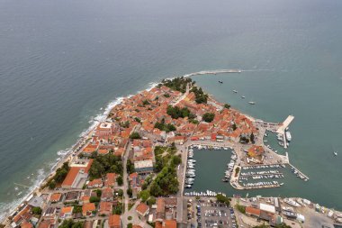 Hırvatistan 'ın Istria kentindeki ortaçağ kıyı kasabası Novigrad' ın çarpıcı hava aracı görüntüsü, kırmızı kiremitli çatılar, botlu marina ve güzel Adriyatik Denizi kıyı şeridini gösteriyor..