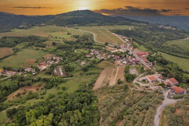 Hırvatistan 'ın İstria kentindeki Motovun yakınlarındaki kayan tepeler ve yeşil vadilerin hava aracı görüntüsü, tarlalar, ormanlar ve dolambaçlı kırsal yollarla.