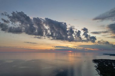 Hırvatistan 'ın Istria kıyısında, sakin Adriyatik Denizi üzerindeki dramatik akşam bulutları, sudaki yumuşak yansımalarla.